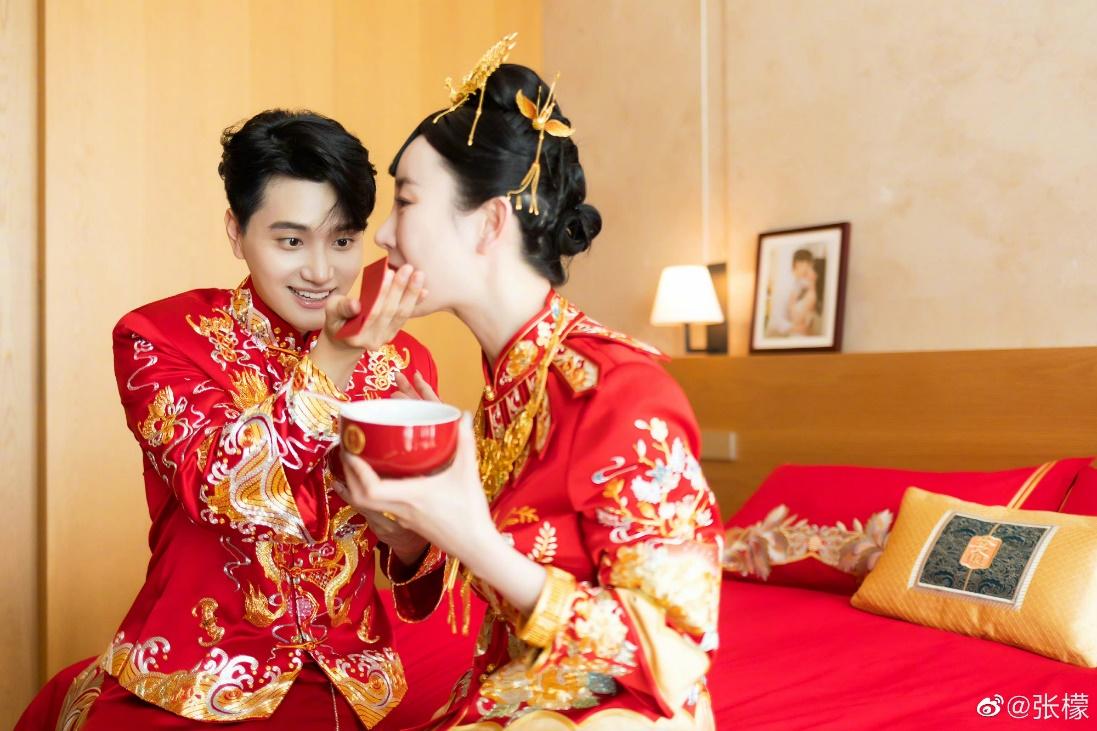 张檬|张檬金恩圣中式婚礼照，两人身穿大红婚服，甜蜜接吻，互喂莲子