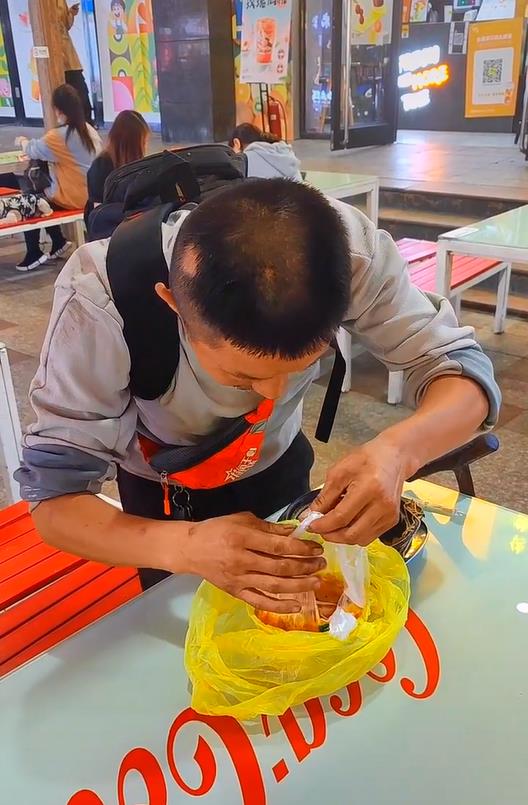 流浪男垃圾桶翻吃食,被好心人给米线却不吃,男子:老婆还没吃饭