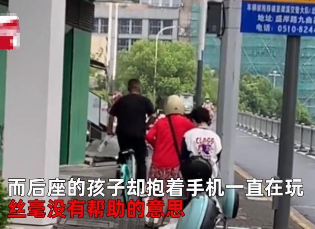 江苏一男孩坐后座抱手机打游戏,妈妈用力推车前行,路人直呼离谱
