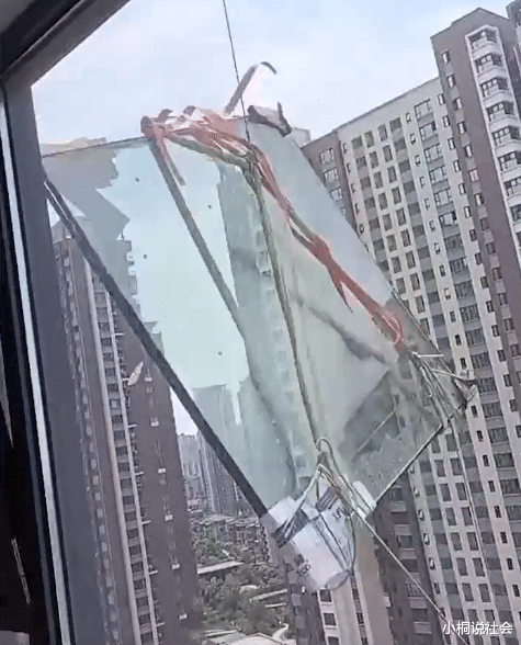 江苏一住户装修吊装玻璃,因风大不停砸向邻居窗户,让人胆战心惊