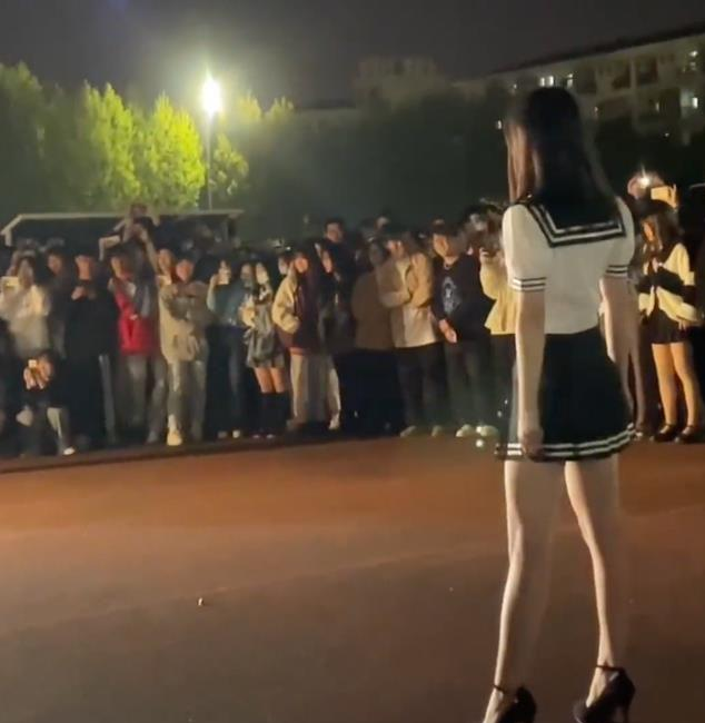 女大学生穿短裙在操场走秀,引发大批学生围观,有人蹲下偷拍裙底