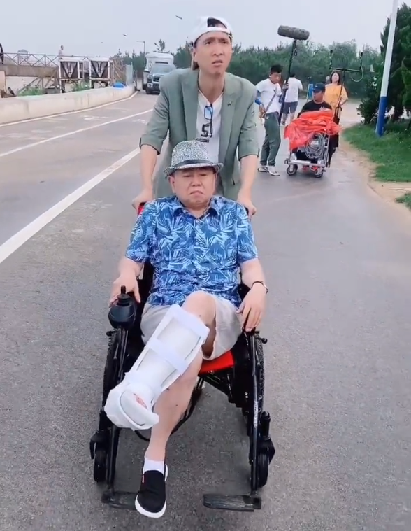 北京国安|太讽刺！65岁潘长江腿摔折后坐轮椅，导演韩兆推车挑战国安队