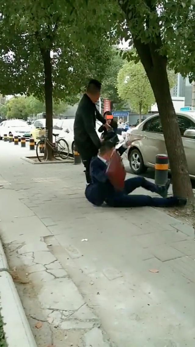 女子朝男子吹口哨,男子回头看却没停下前进的脚步,不慎撞树上