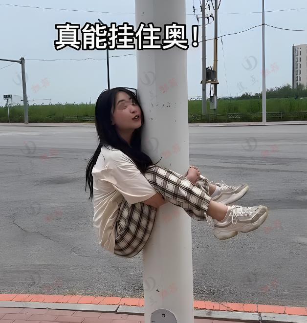 女子和男友玩游戏,挂在路灯杆上下不来,路人乐开花:捡个女友