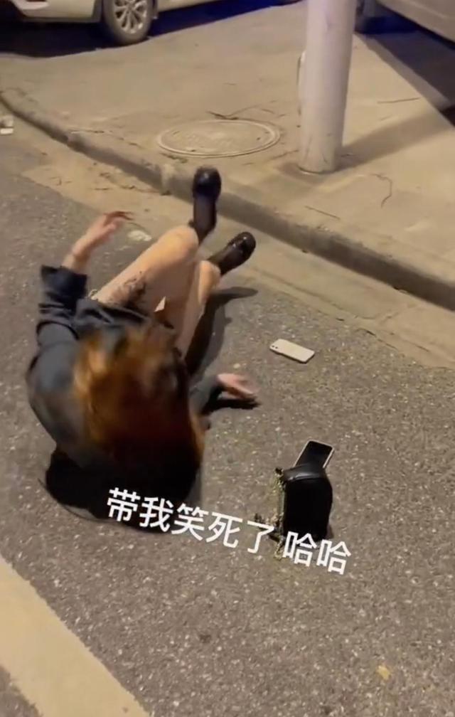 一名醉酒的女子,分不清东西南北,在马路边上爬来爬去