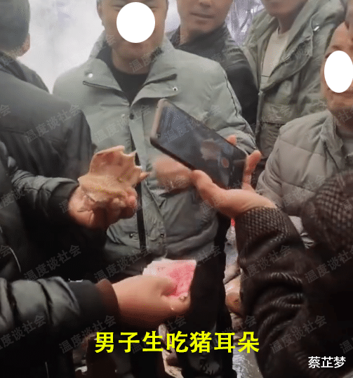 男子为了500元生吃猪耳，一手拿钱一手拿着猪耳朵，吃得津津有味