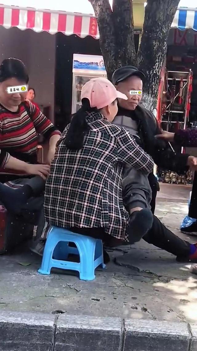 七旬大爷背靠大树,三位中年大妈给其揉腿,网友:我也想要这待遇