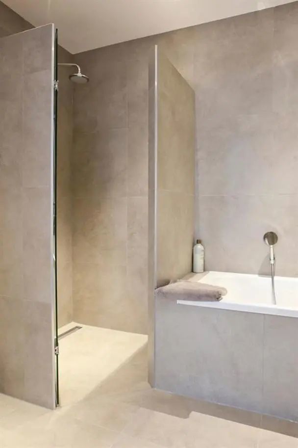 卫生间不大,坚持围着墙角砌2堵墙,两边分功能区中间多个淋浴房