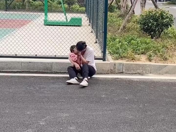 一女子被婆婆赶出家门,感到委屈,带着孩子坐在地上哭