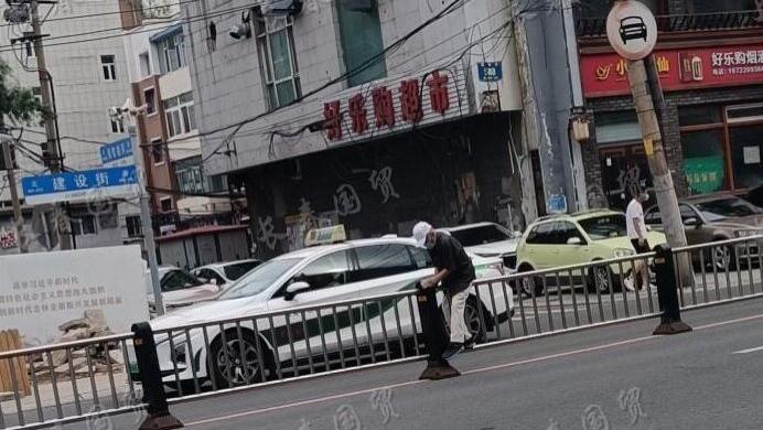 长春一老人横穿马路，在违章翻越护栏时尴尬了，多亏好心路人出手