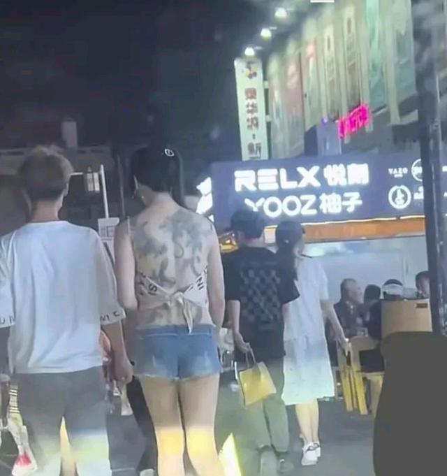 夜晚女子穿一块布逛街回顾,满背纹身引发关注,男友贴心保护
