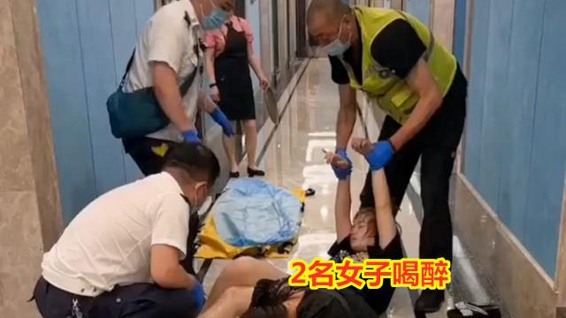 2名女子穿着清凉，喝醉后躺地上扭动，3个大叔将她抬走