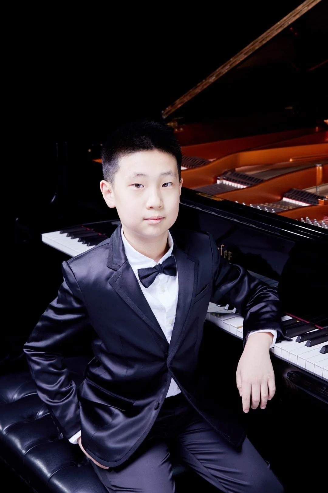 林永健儿子不简单，小小年纪钢琴过英皇八级，穿黑色西服套装五官气质都神似老爸