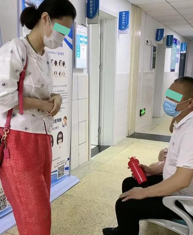 女子排队看病时坐在丈夫的腿上,一旁的男子:旁边有座位可以坐