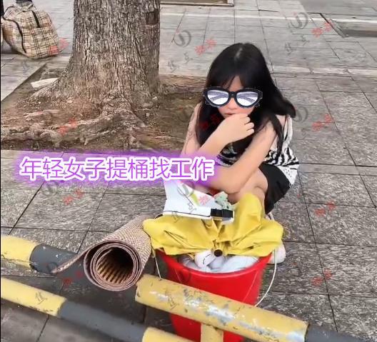 年轻女子提桶在街头找工作,“我还年轻要求不高,月薪至少1万”
