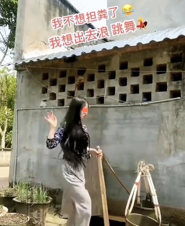 女子挑粪去给庄稼施肥,没有一丝不快,反而自娱自乐在粪坑旁跳舞