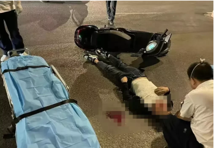 江苏南京，一名男子正在路边等出租车，只听“砰”的一声，一位骑摩托车的男子突然撞到马路边的石墩上