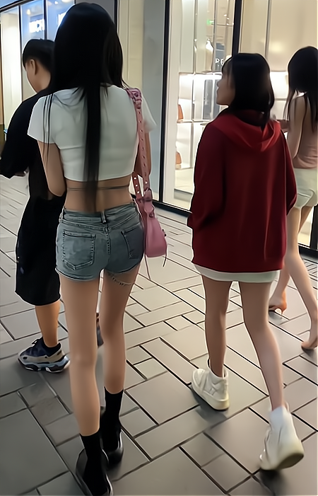 女子的短裤上挂了一根绳子,奇特造型引人关注,大叔跟着拍了一路