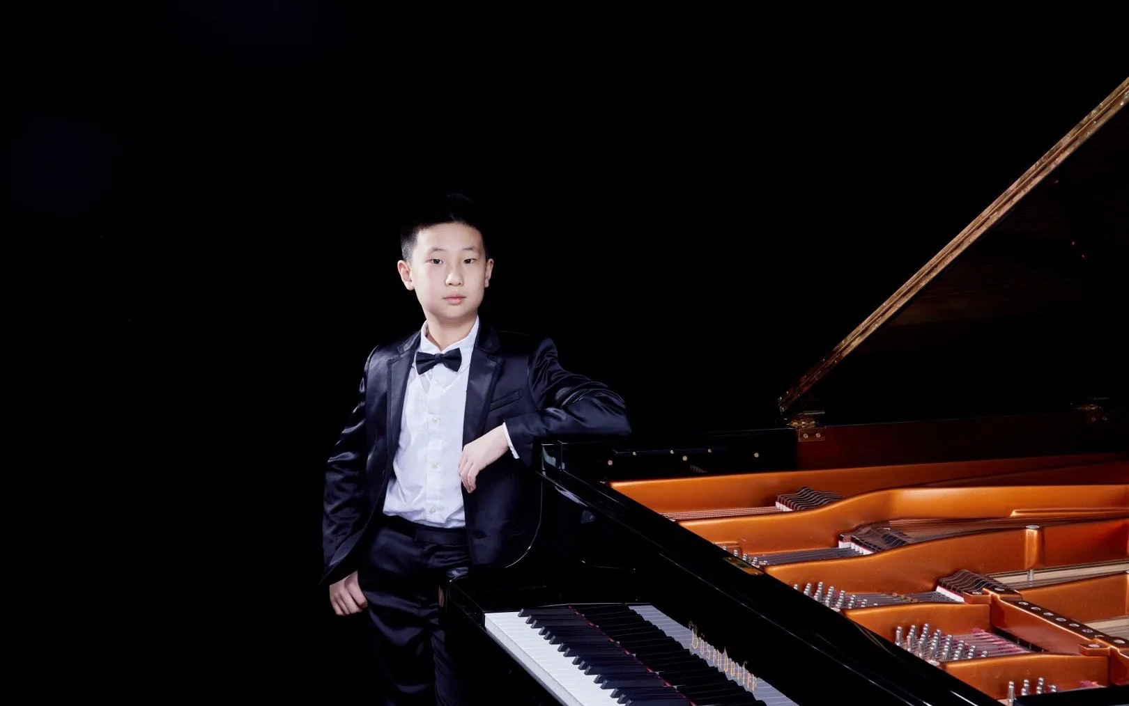 林永健儿子不简单，小小年纪钢琴过英皇八级，穿黑色西服套装五官气质都神似老爸