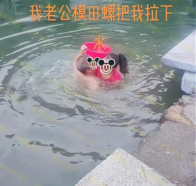 男子在水塘里摸田螺,妻子在岸上观看,他趁妻子不备把她拉下水