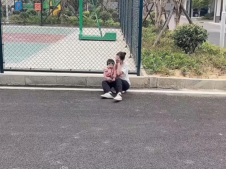 一女子被婆婆赶出家门,感到委屈,带着孩子坐在地上哭