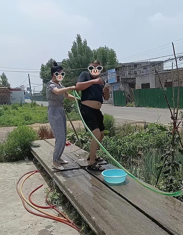 一女子让丈夫浇地,他却只顾玩手机,女子将水管插到他的裤子里