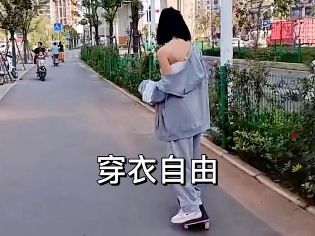 武汉女子在路边玩滑板，一边滑衣服一边往下掉！网友：每个动作都是心机！