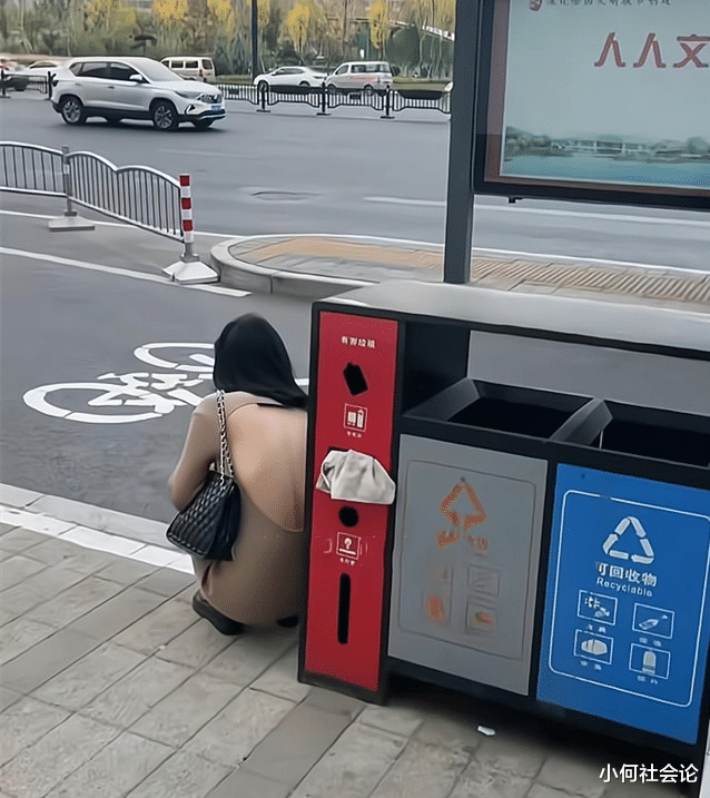 女子衣着单薄街头等车,露着后背浑身直打颤,躲在垃圾桶旁避风