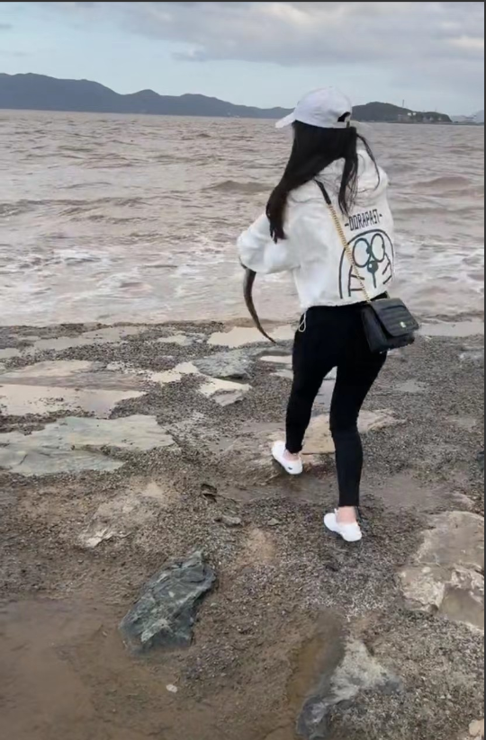 浙江舟山。一女子和朋友到海边游玩,离得远远地就看见一条大鱼躺在岸边上