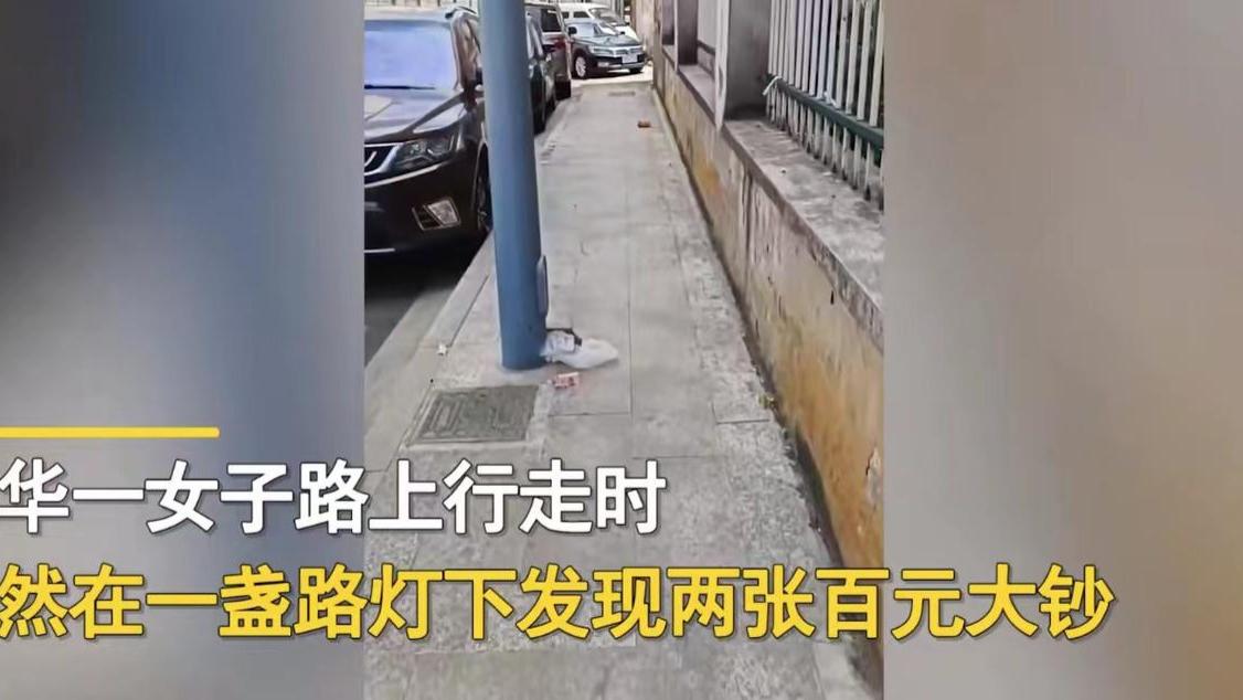 浙江金华。一女子回家路上突然在一盏路灯下看到两张红彤彤的百元大钞