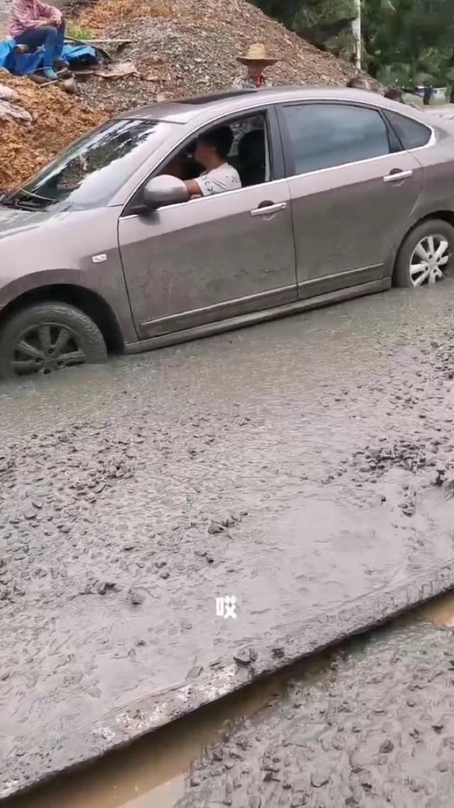 男子驾车经过未修好的路面,陷入水泥浆中,村民:不听劝的后果