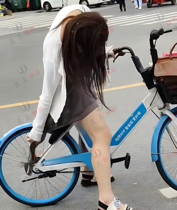 女子骑单车裙子卡住链条，旁边一群人排队却无人帮忙，让人心酸