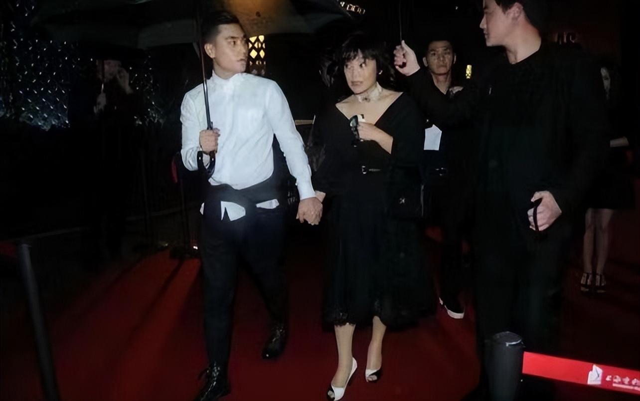 张艾嘉儿子可以出道了,外套拦腰系腰上看不懂,雨中牵妈妈很温柔