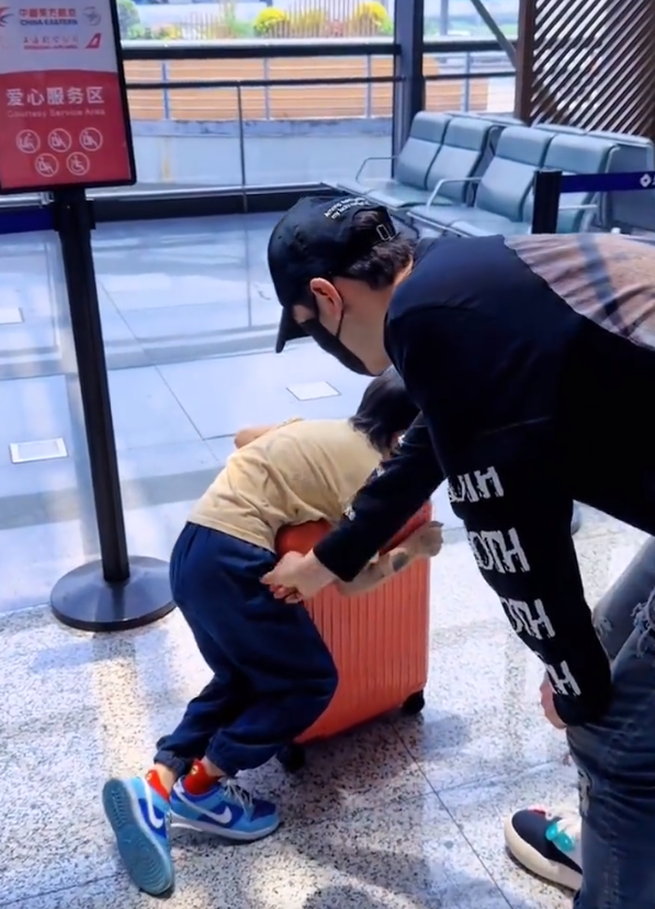 黄晓明带儿子现身机场，跪地上给儿子擦汗，小海绵玩行李箱不慎摔倒 ?