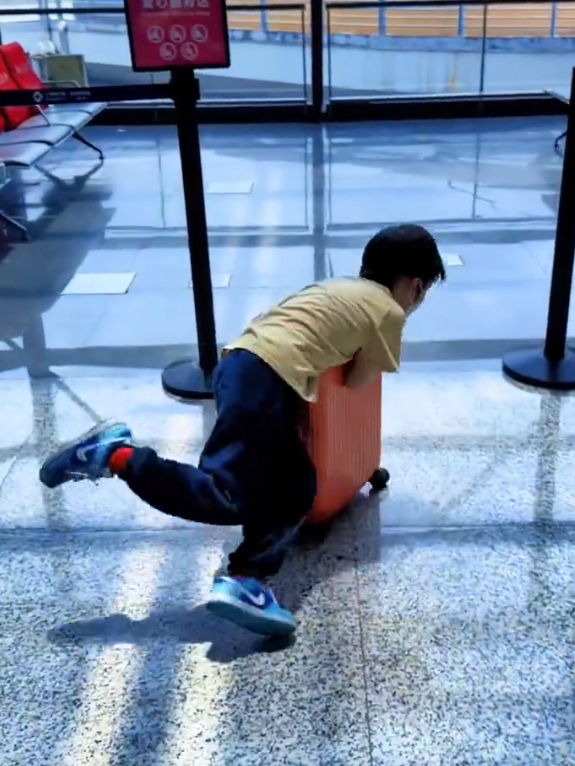 黄晓明带儿子现身机场，跪地上给儿子擦汗，小海绵玩行李箱不慎摔倒 ?