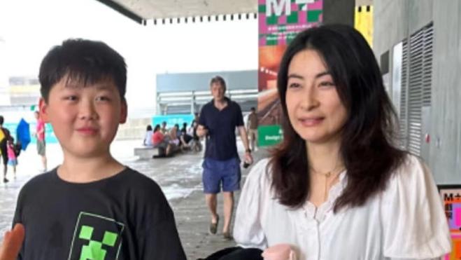 郭晶晶接娃被偶遇，穿黑裙头发蓬乱似妇女，与孩子雨中漫步超开心