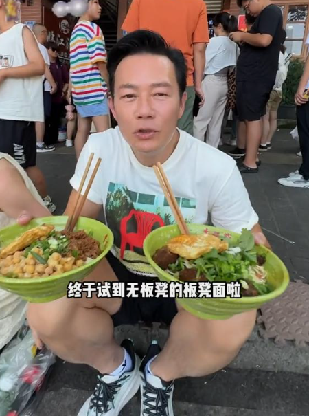 60岁香港影帝游重庆,蹲路边吃小面辣得满脸大汗,吃完还喊爽