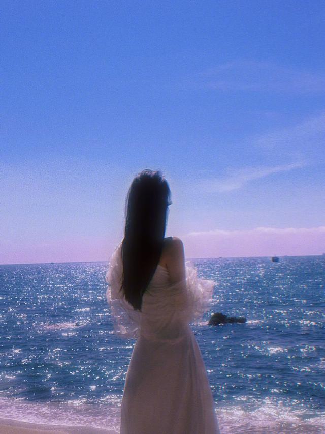 张馨予|女星张馨予分享海边写真,身穿白色吊带长裙,长发美颜融入海天里