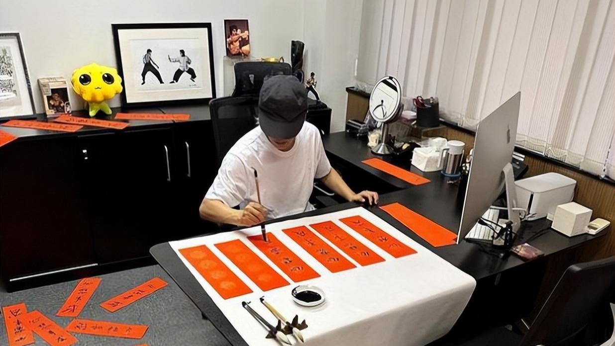 周星驰|周星驰在办公室写“心想事成”符，桌子上摆着李小龙和他的功夫照