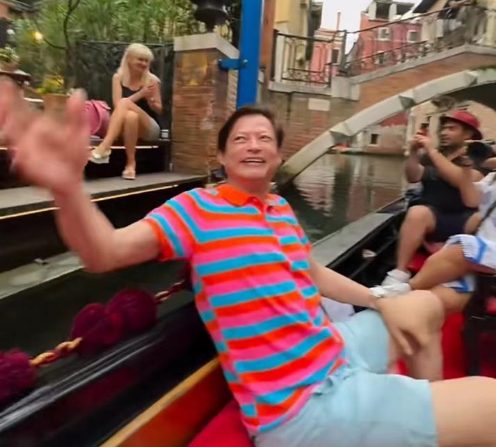 65岁莫华伦携二婚娇妻出游!激动唱歌活力四射,女方穿抹胸身材好