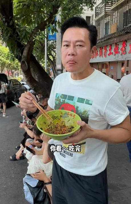 60岁香港影帝游重庆,蹲路边吃小面辣得满脸大汗,吃完还喊爽