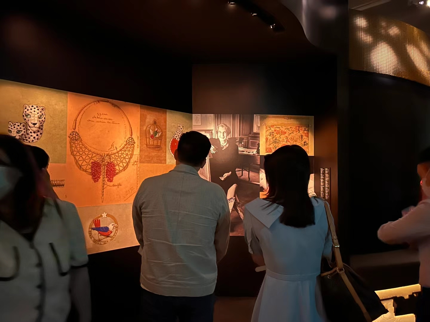 霍启刚陪妻子看卡地亚展,郭晶晶穿白色带领长裙,挎着大包超少女