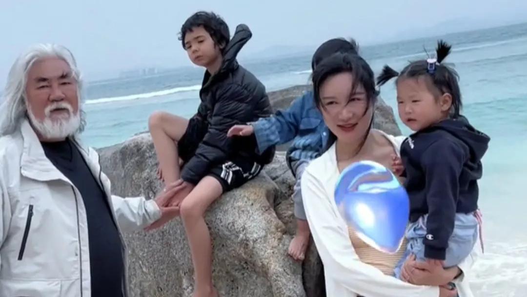 鲜花|张纪中夫妇穿睡衣逛街，男方强撑抱娃很吃力，走路一瘸一拐