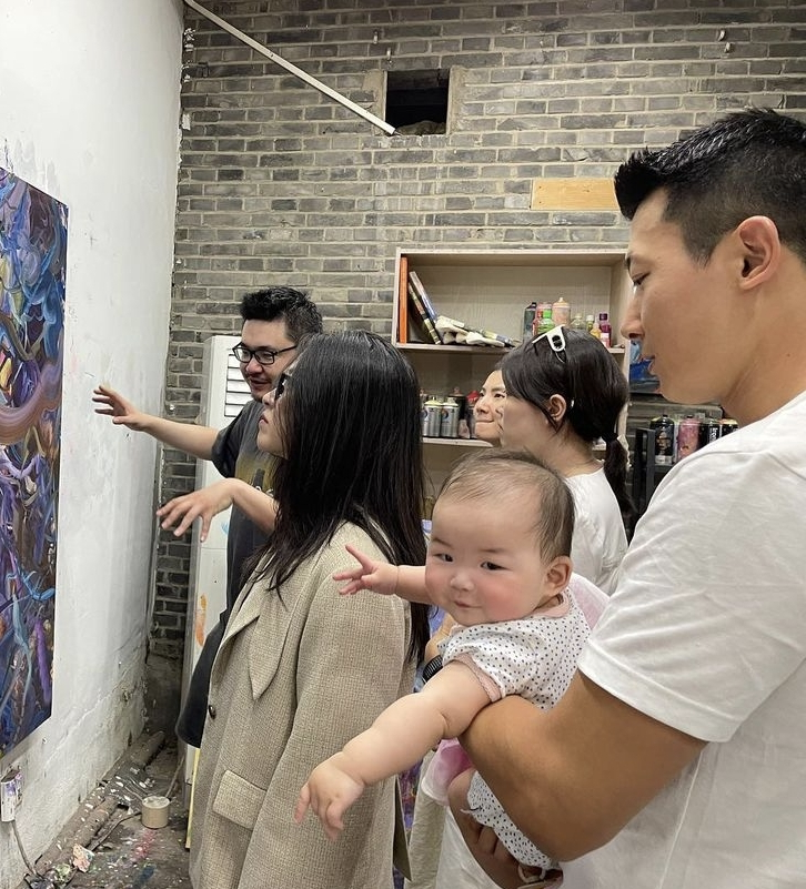 |朱珠工作老公带娃忙,父女俩戴棒球帽看艺术展,坐在板凳上像套娃