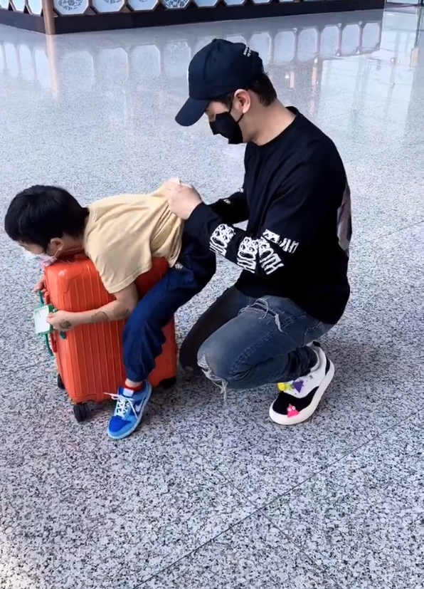 黄晓明带儿子现身机场，跪地上给儿子擦汗，小海绵玩行李箱不慎摔倒 ?