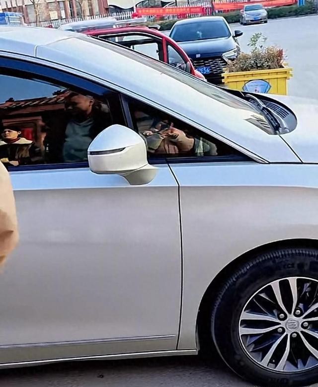 接地气!刘强东父母低调坐车离开光明村,不忘用红色桶带着农货