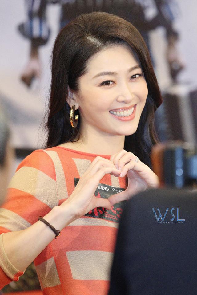 漂亮女星周励淇身穿橙色花纹连衣裤出席首映礼，新片中有打斗场面