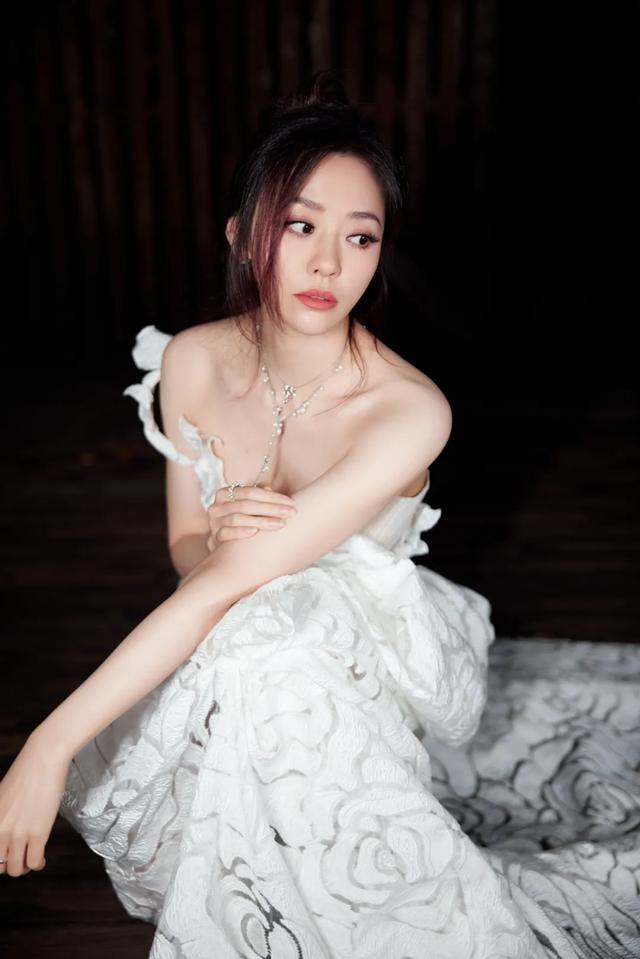 张靓颖，身着一袭白色长裙，宛如月光下绽放的百合
