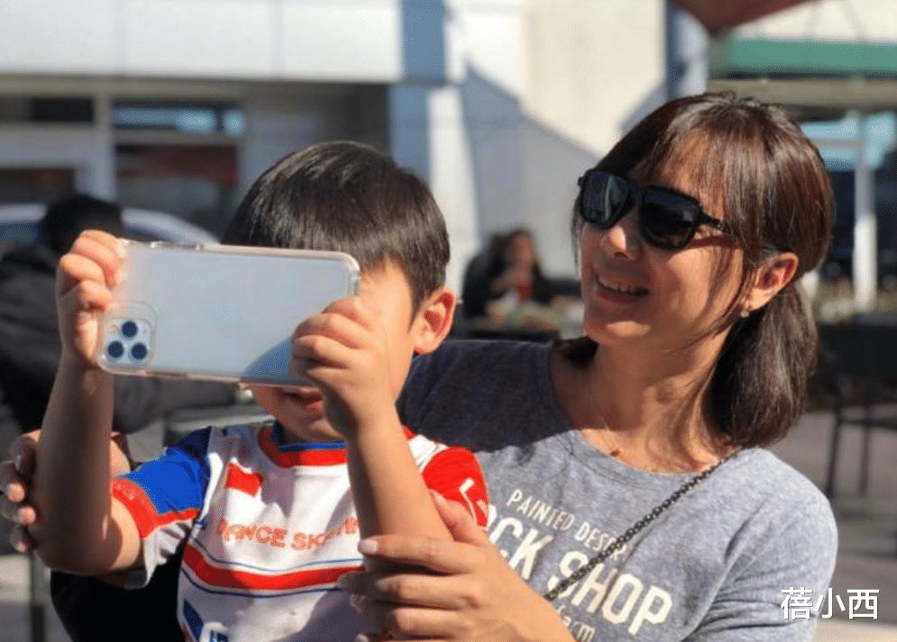 49岁徐静蕾罕见抱小男孩拍照,穿灰T恤+半扎短发,美得像换了个人