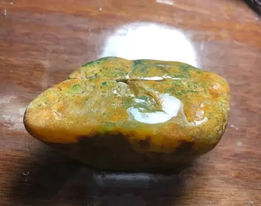 一块翡翠原石，一切两块飘绿色的双龙戏珠